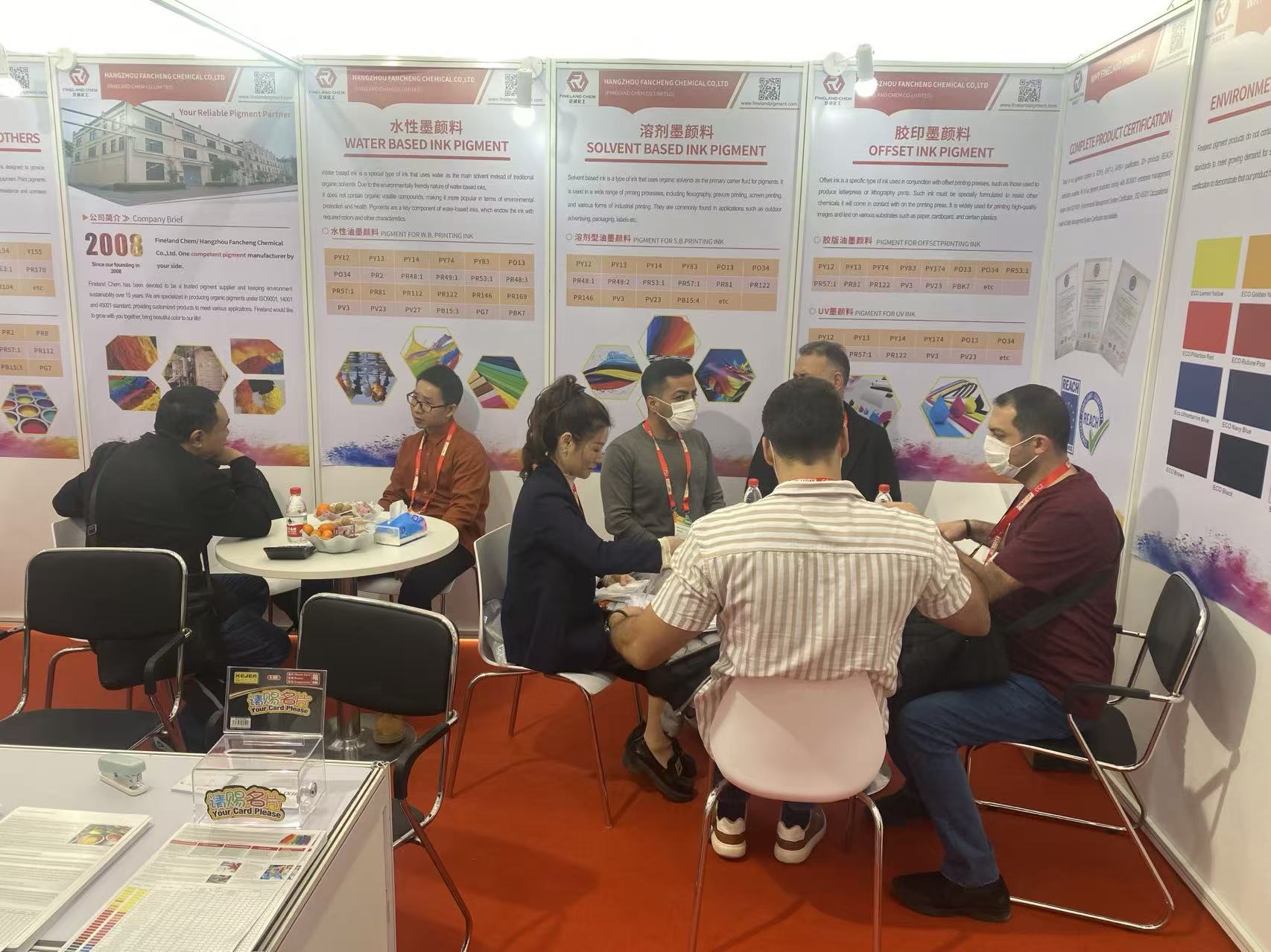 Visitors at Fineland Chem booth discussing pigment solutions